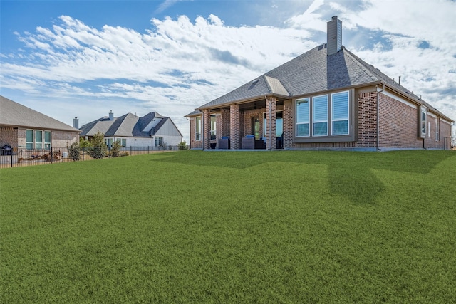 rear view of house featuring a yard