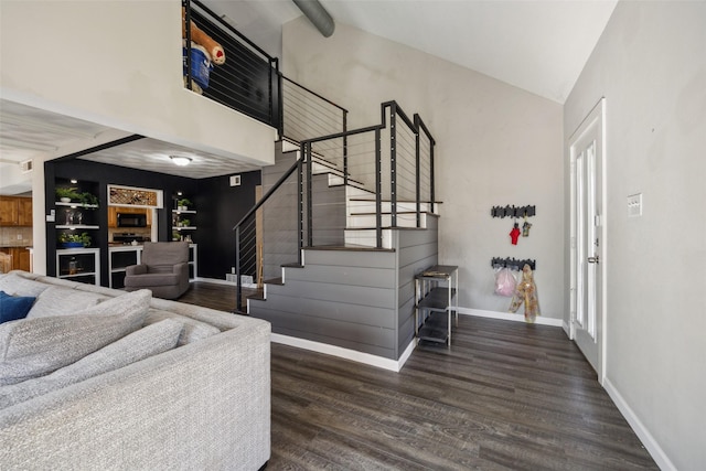 stairs with wood-type flooring and high vaulted ceiling