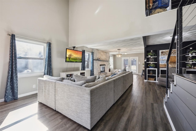 living room featuring a healthy amount of sunlight, dark hardwood / wood-style floors, and a high ceiling