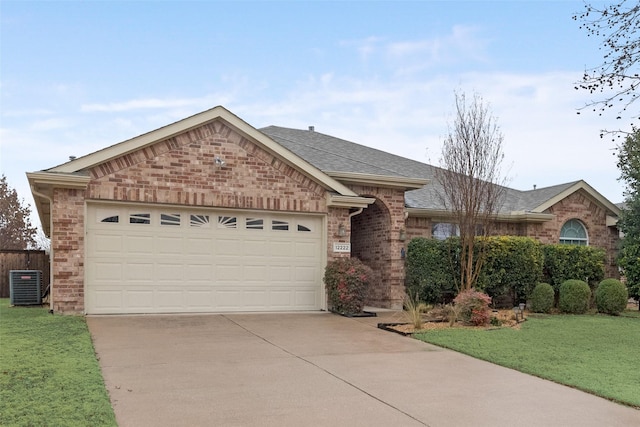 ranch-style house featuring a garage, central AC, and a front yard