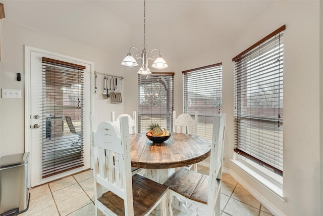 tiled dining room with an inviting chandelier