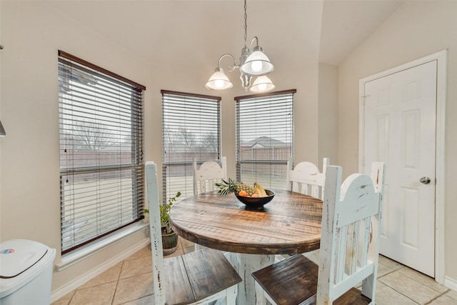 tiled dining area with lofted ceiling and a chandelier