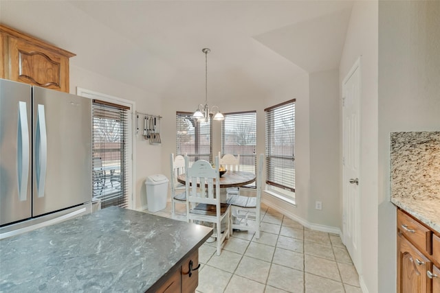 tiled dining area featuring a chandelier