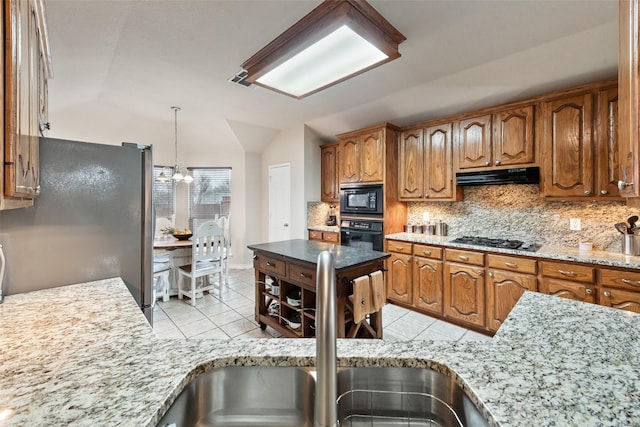 kitchen featuring lofted ceiling, sink, light tile patterned floors, black appliances, and decorative backsplash