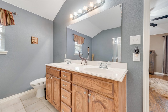 bathroom featuring vanity, toilet, tile patterned flooring, and vaulted ceiling