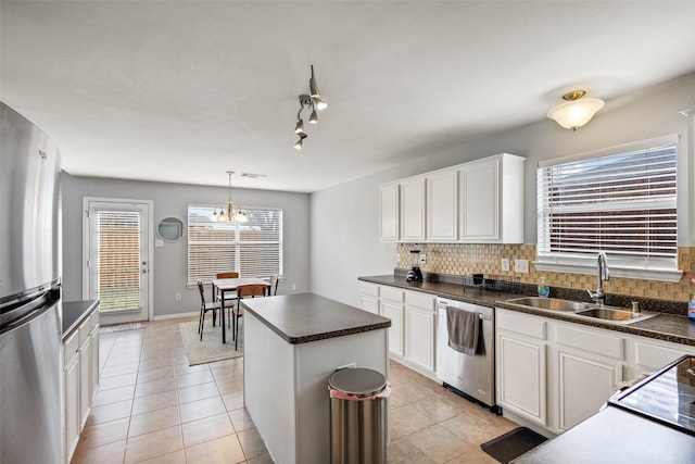 kitchen featuring appliances with stainless steel finishes, a center island, sink, and white cabinets