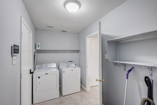 laundry room featuring separate washer and dryer and light tile patterned floors