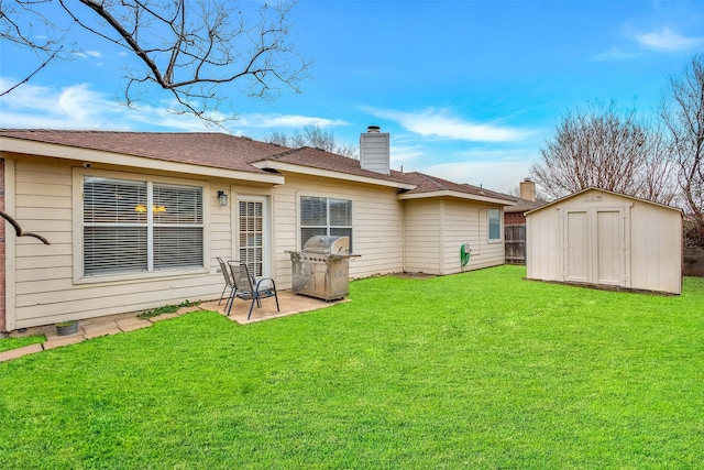 rear view of house featuring a patio, a yard, and a shed