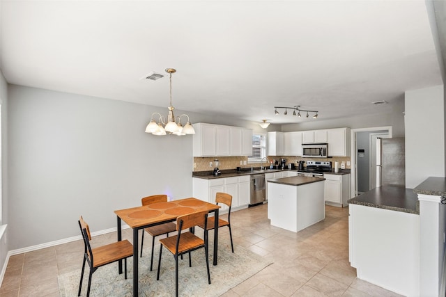 dining area with sink, light tile patterned floors, and a notable chandelier