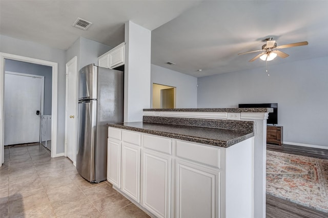 kitchen with stainless steel refrigerator, white cabinetry, kitchen peninsula, and ceiling fan