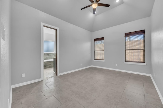 tiled empty room with vaulted ceiling and ceiling fan