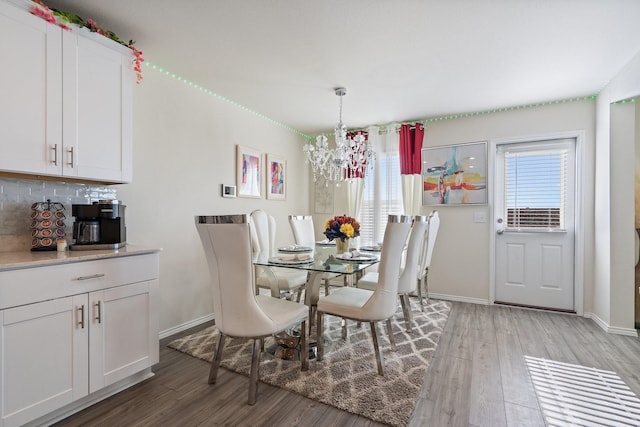 305 Grenada Lake Dr, Princeton, TX 75407 - dining area with a notable chandelier, a wealth of natural light, and wood-type flooring
