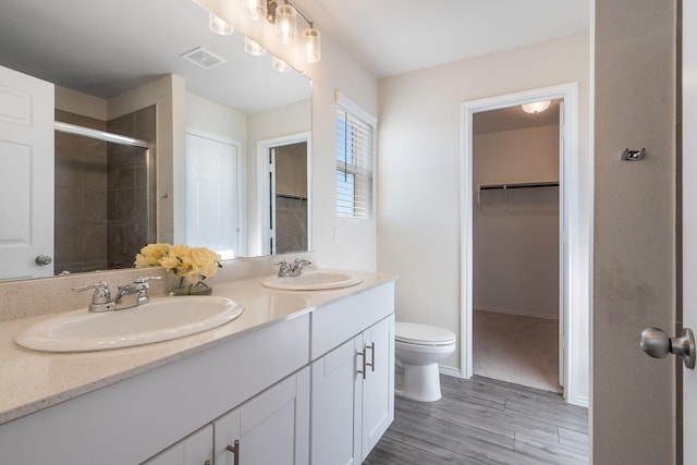 305 Grenada Lake Dr, Princeton, TX 75407 - bathroom featuring vanity, toilet, an enclosed shower, and hardwood / wood-style floors