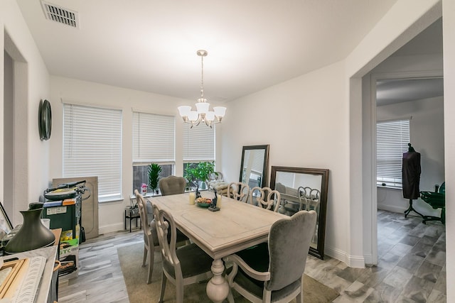 dining space with a notable chandelier and light hardwood / wood-style flooring