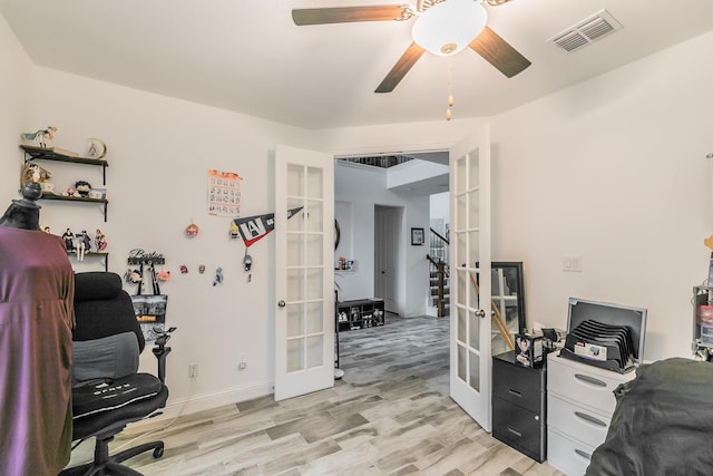 office area with french doors, ceiling fan, and light wood-type flooring