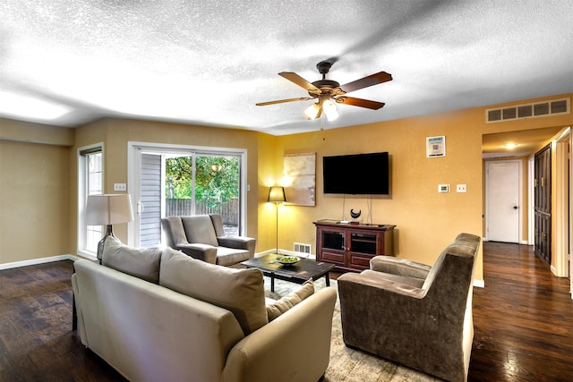 living room featuring ceiling fan, dark hardwood / wood-style floors, and a textured ceiling