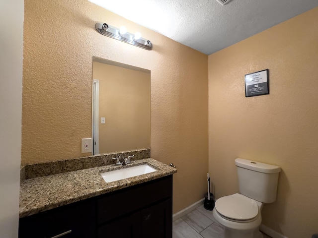 bathroom featuring vanity, tile patterned flooring, and toilet