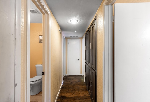 corridor featuring dark hardwood / wood-style floors and a textured ceiling