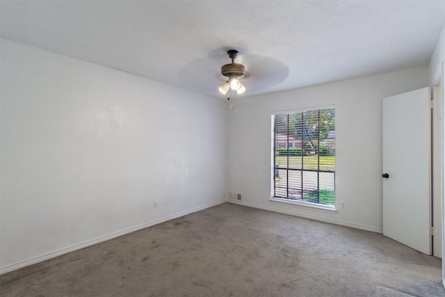 spare room featuring light carpet and ceiling fan