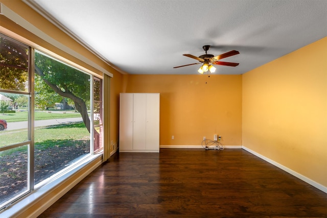 spare room with a textured ceiling, dark hardwood / wood-style floors, and ceiling fan