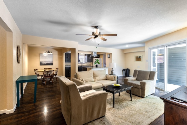 living room with ceiling fan, dark wood-type flooring, and a textured ceiling