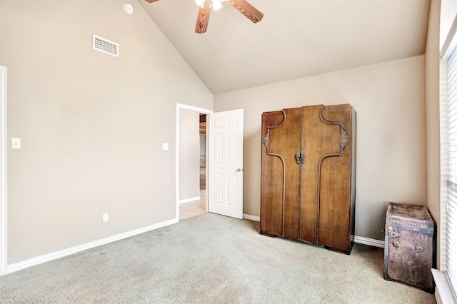 unfurnished bedroom with high vaulted ceiling, light colored carpet, and ceiling fan