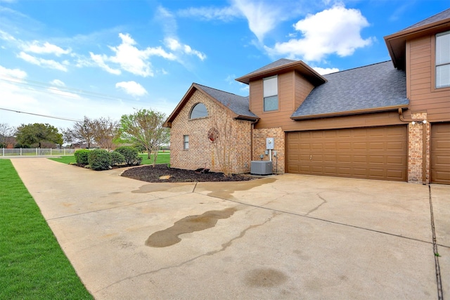 view of front of home featuring central AC unit and a garage