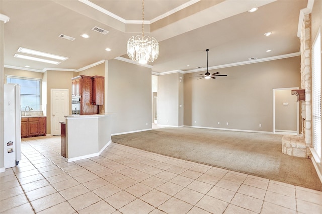 unfurnished living room with ceiling fan with notable chandelier, sink, a tray ceiling, crown molding, and light carpet