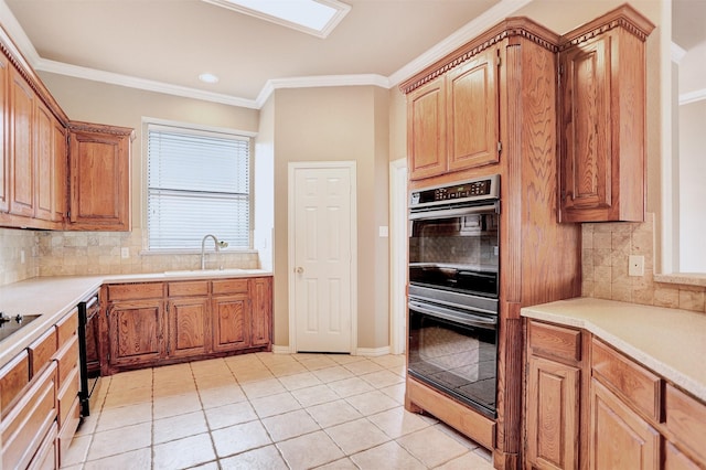 kitchen with crown molding, sink, light tile patterned flooring, and double oven