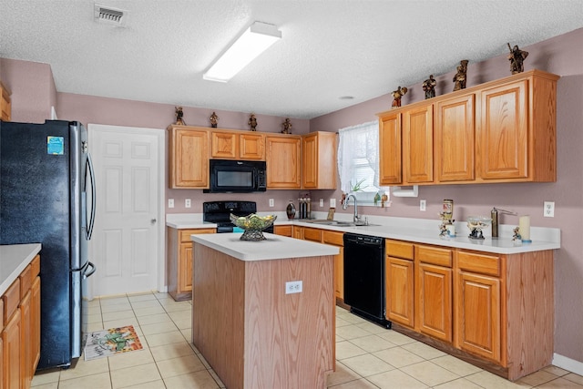 kitchen featuring light tile patterned flooring, a kitchen island, sink, black appliances, and a textured ceiling