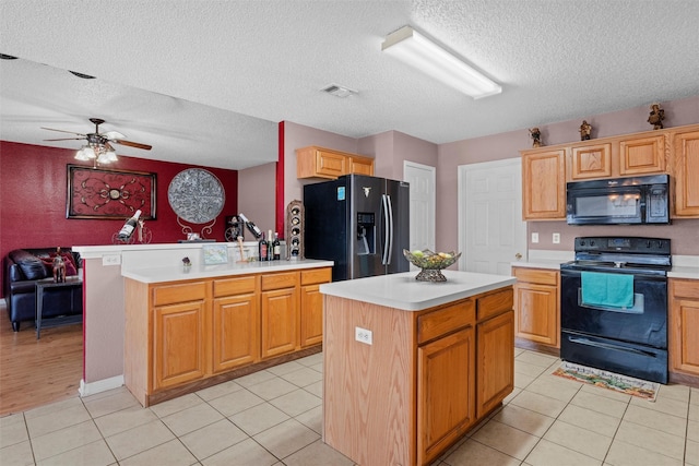 kitchen with light tile patterned floors, black appliances, and a center island