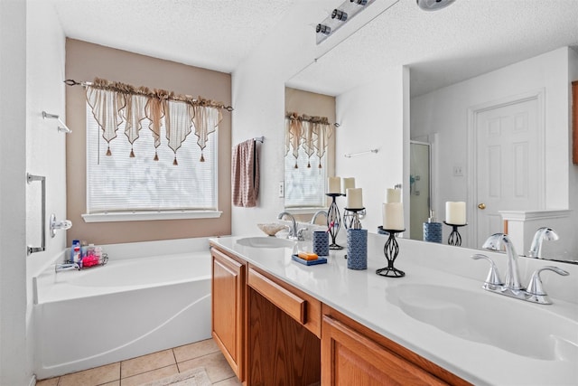 bathroom featuring vanity, a healthy amount of sunlight, tile patterned floors, and a textured ceiling