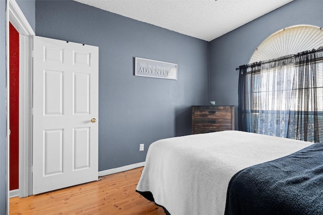 bedroom with hardwood / wood-style flooring and a textured ceiling