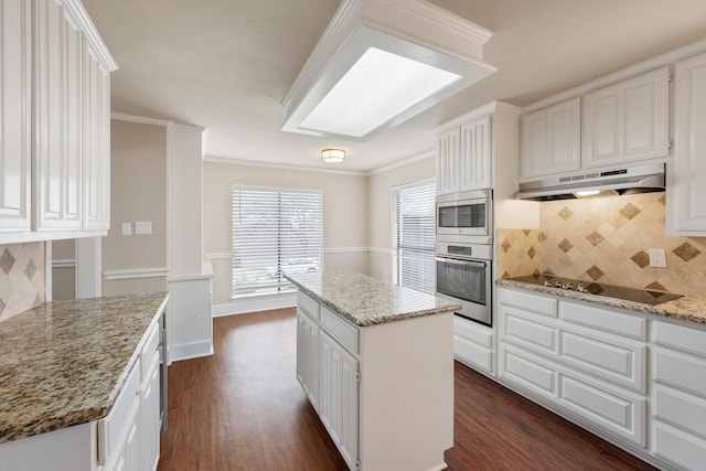 kitchen featuring a kitchen island, light stone countertops, appliances with stainless steel finishes, and white cabinets