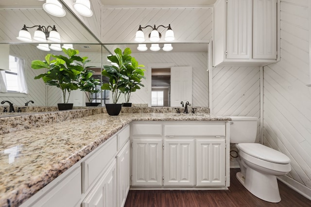 bathroom with hardwood / wood-style flooring, vanity, and toilet