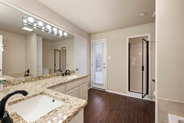 bathroom featuring tiled shower, vanity, toilet, and hardwood / wood-style floors