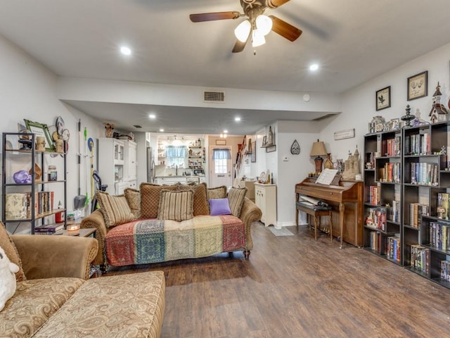 living room with dark hardwood / wood-style flooring and ceiling fan