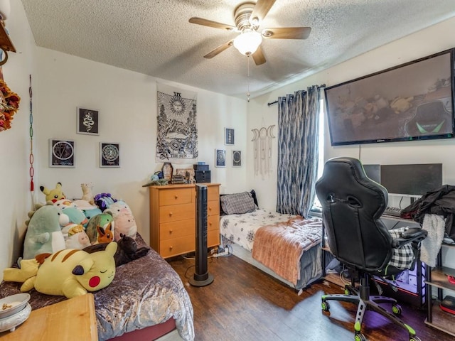 bedroom featuring dark hardwood / wood-style flooring, ceiling fan, and a textured ceiling