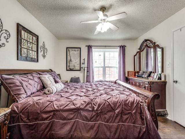 bedroom featuring ceiling fan, hardwood / wood-style floors, and a textured ceiling