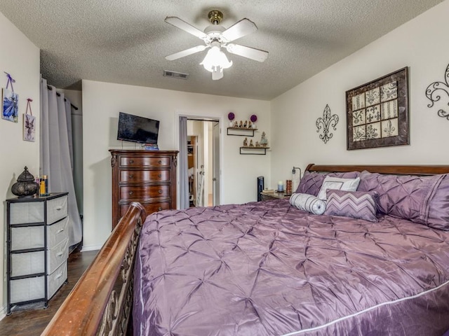 bedroom with hardwood / wood-style floors, a textured ceiling, and ceiling fan