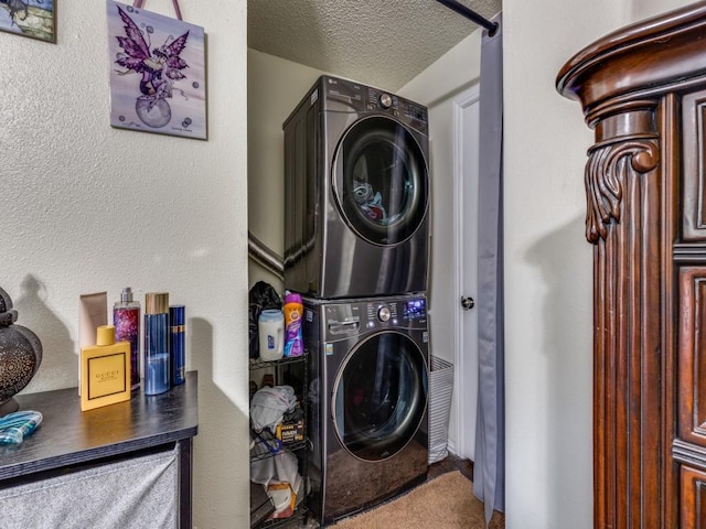 laundry area featuring stacked washer / drying machine and a textured ceiling