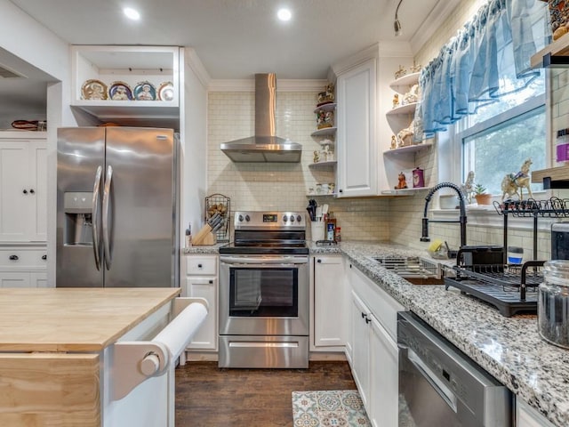 kitchen with appliances with stainless steel finishes, dark hardwood / wood-style floors, wooden counters, white cabinets, and wall chimney range hood