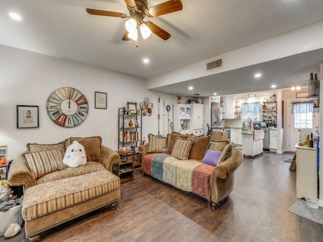 living room featuring dark wood-type flooring and ceiling fan