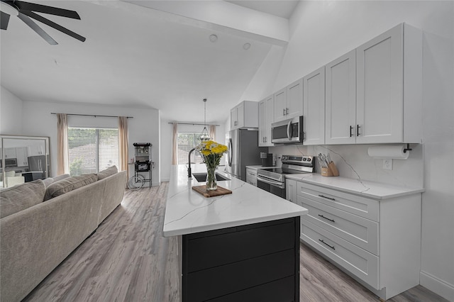 kitchen with sink, white cabinetry, an island with sink, stainless steel appliances, and light stone countertops