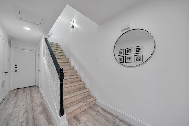 staircase with hardwood / wood-style floors