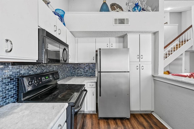 kitchen featuring dark hardwood / wood-style floors, white cabinetry, decorative backsplash, black appliances, and a textured ceiling