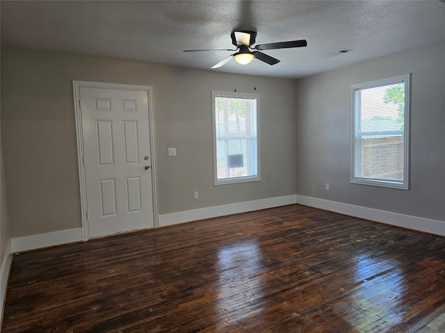 unfurnished room with ceiling fan, dark wood-type flooring, and a textured ceiling