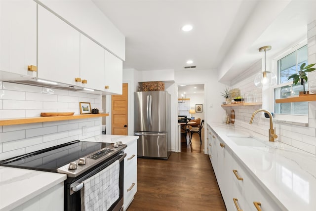 kitchen with pendant lighting, sink, appliances with stainless steel finishes, white cabinetry, and light stone countertops