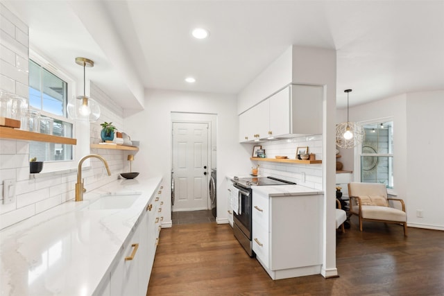 kitchen with sink, white cabinetry, light stone counters, decorative light fixtures, and electric range