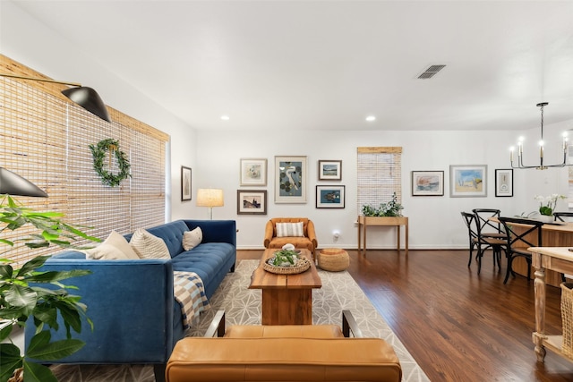 living room with dark hardwood / wood-style floors and a notable chandelier